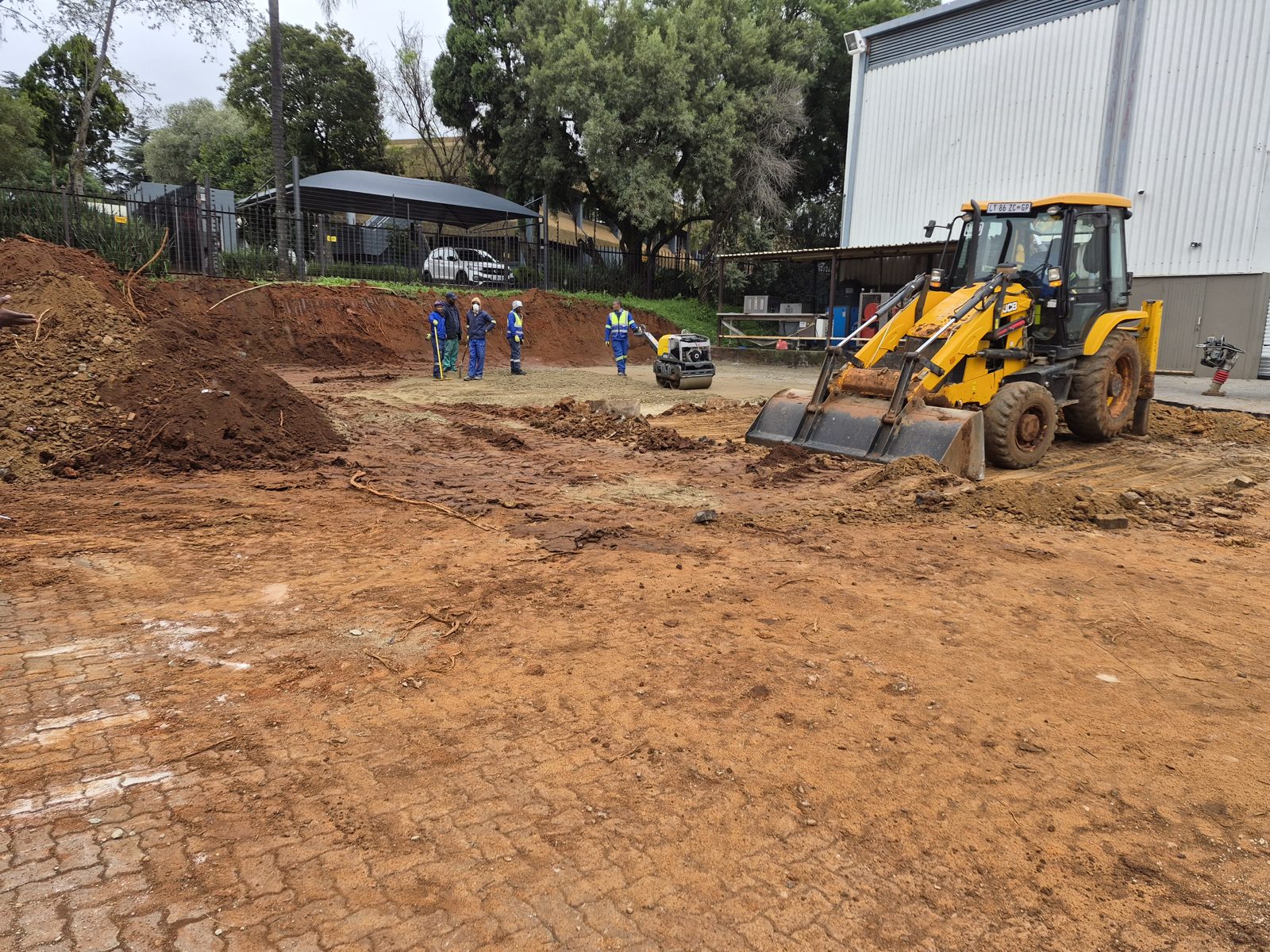 JCB and roller compacting a site platform