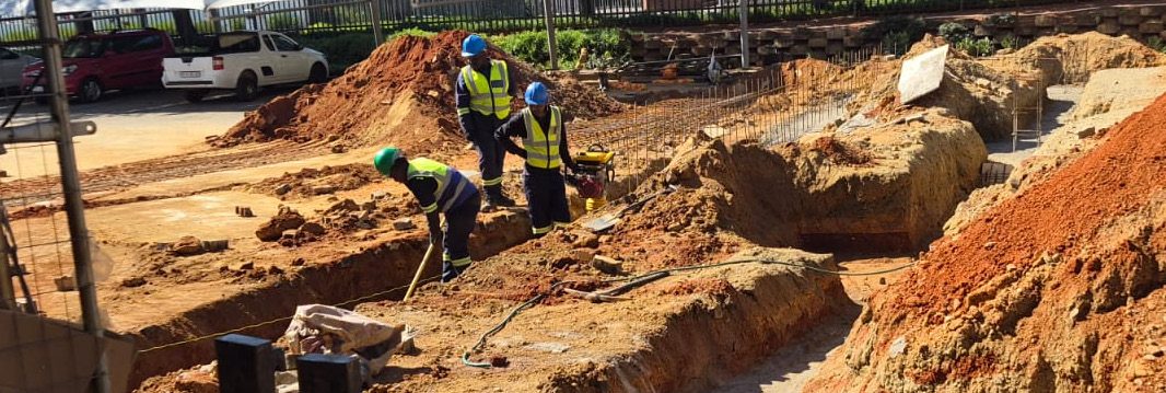 Linasi team compacting soil in foundation trenches